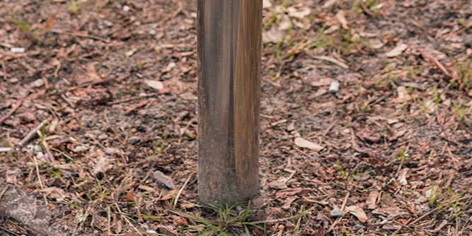 Poteau pour voile d'ombrage scellé dans un jardin