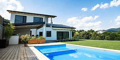 Terrasse de maison en bois avec piscine et jardin à ombrager