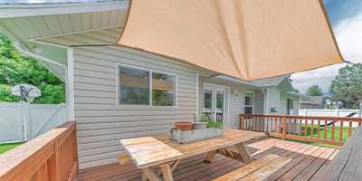 voile d'ombrage installée par-dessus une terrasse de jardin